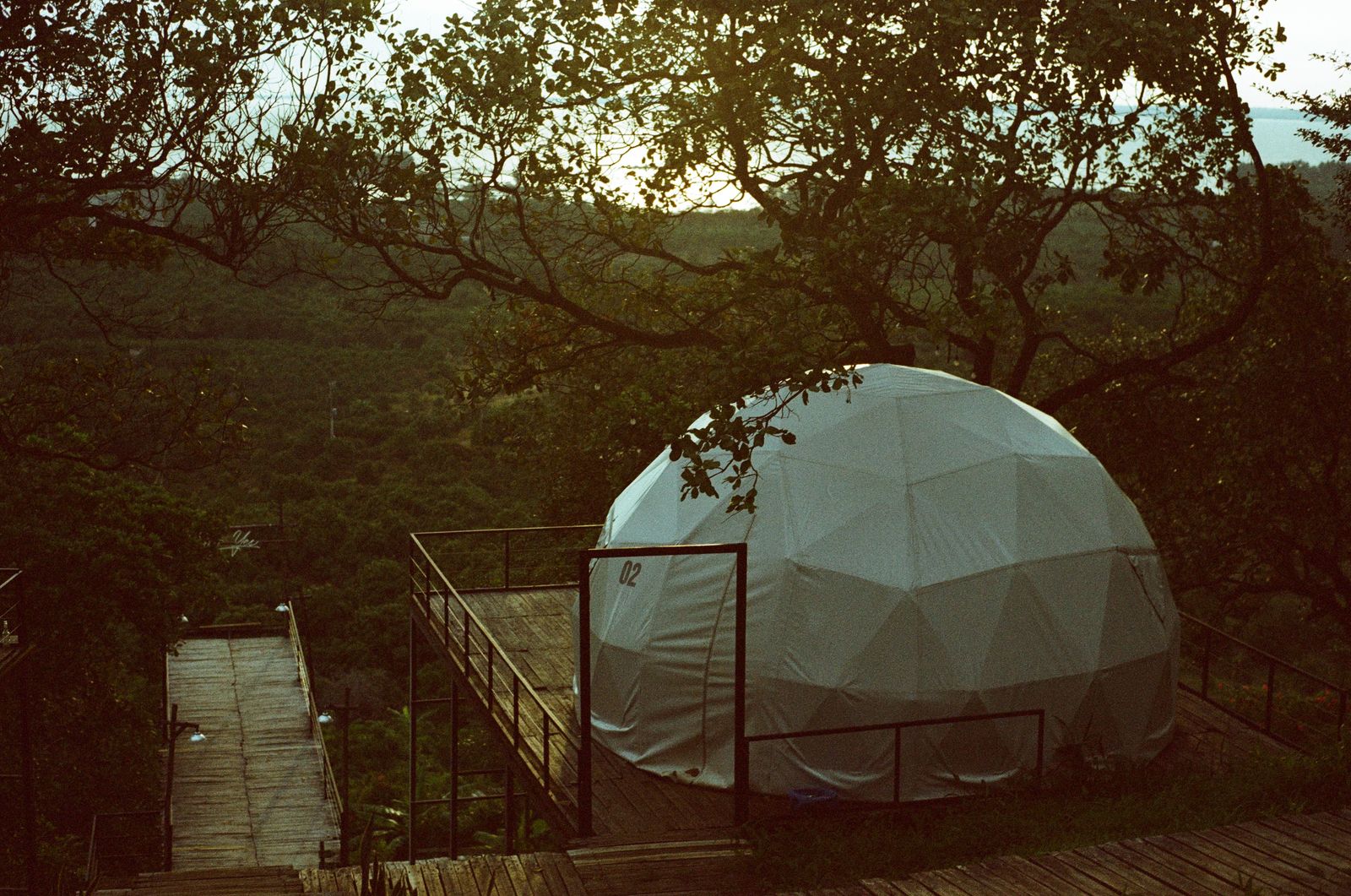 A unique glamping dome lit warmly at dusk under a starry prairie sky