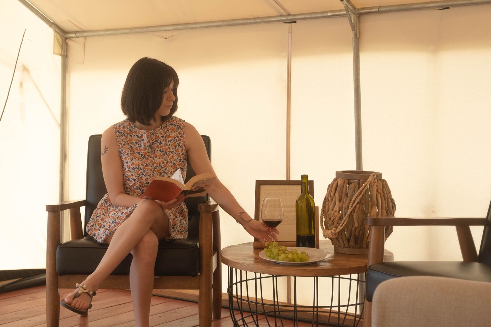 A guest unwinding with a book and a drink at a relaxing unique-stay retreat