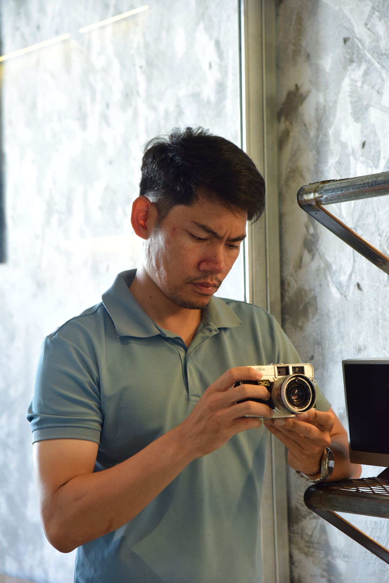 A photographer with a camera in a sunlit interior