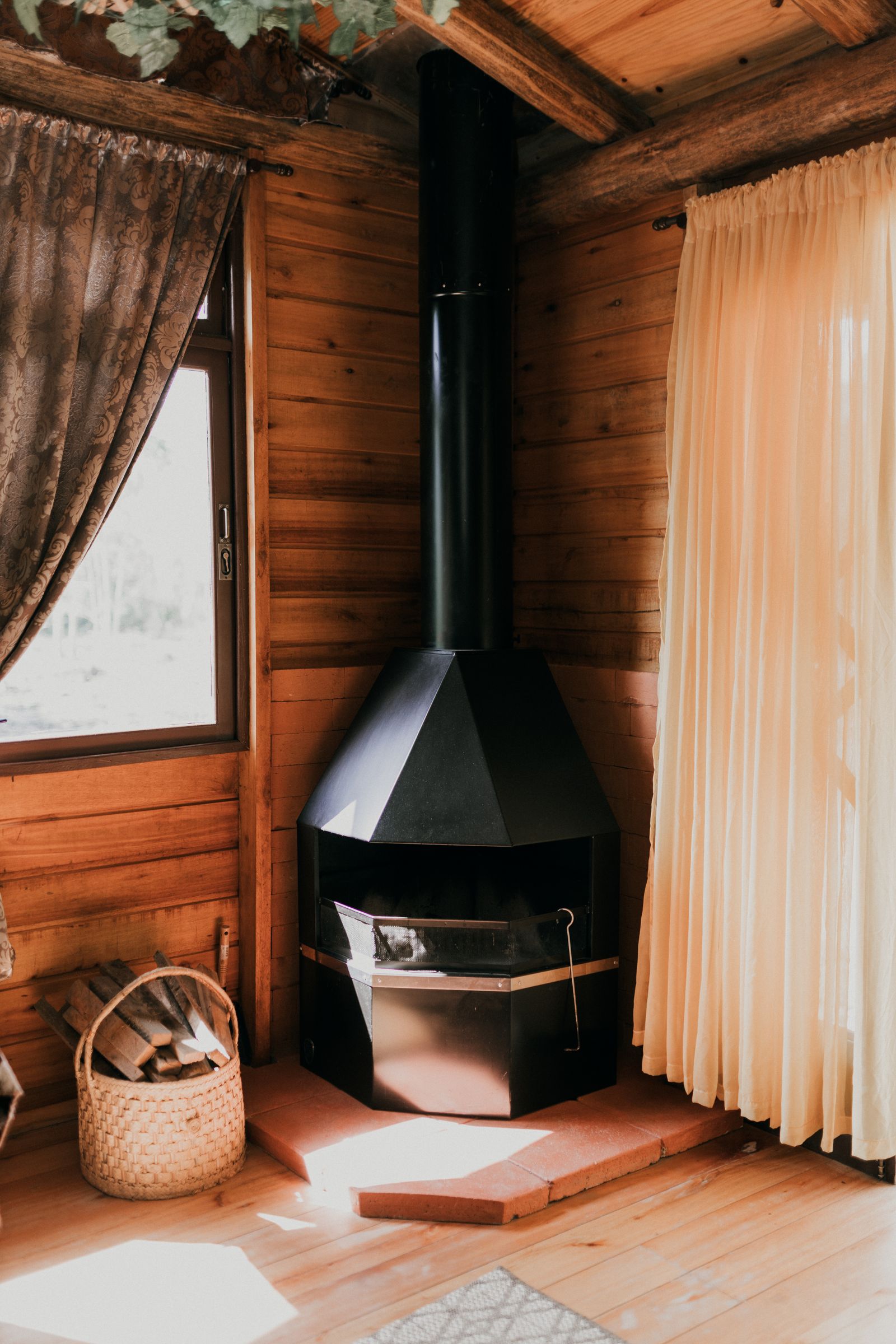 A beautifully lit, cozy cabin interior with a wood stove