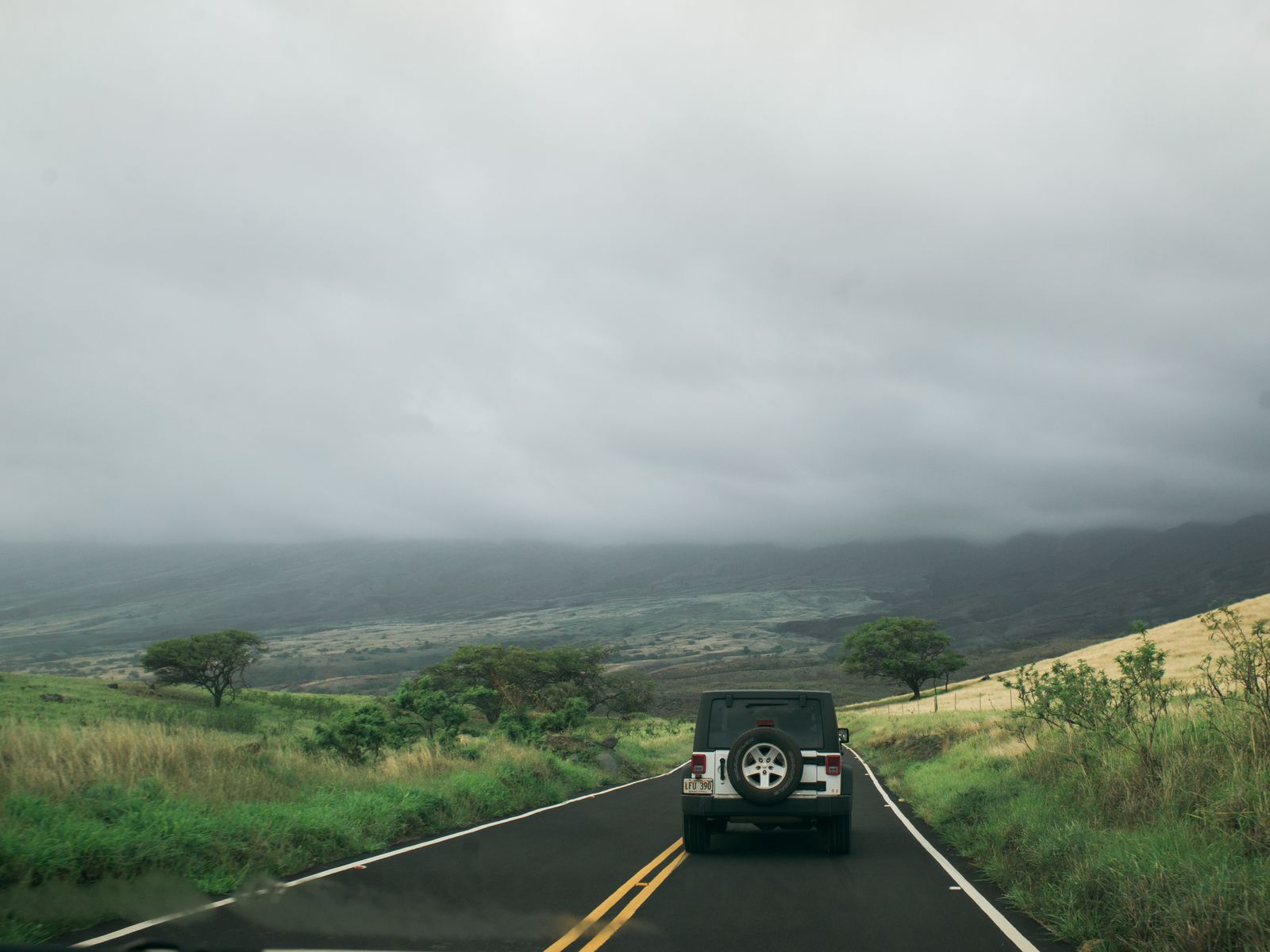 A car on a scenic country road heading toward a weekend getaway