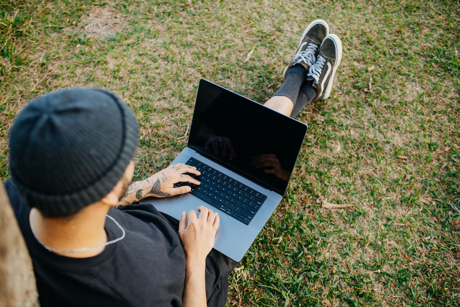 A farmer catching up on messages on a laptop outdoors